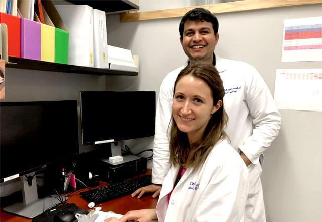 researchers in jones lab stand by desk