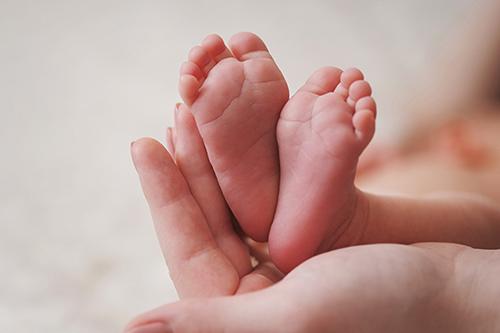Infant feet in hand